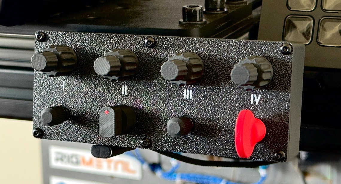 May include: A black control panel with four knobs and four buttons. The knobs are labeled I, II, III, and IV. The buttons are black and red. The panel has a textured surface.